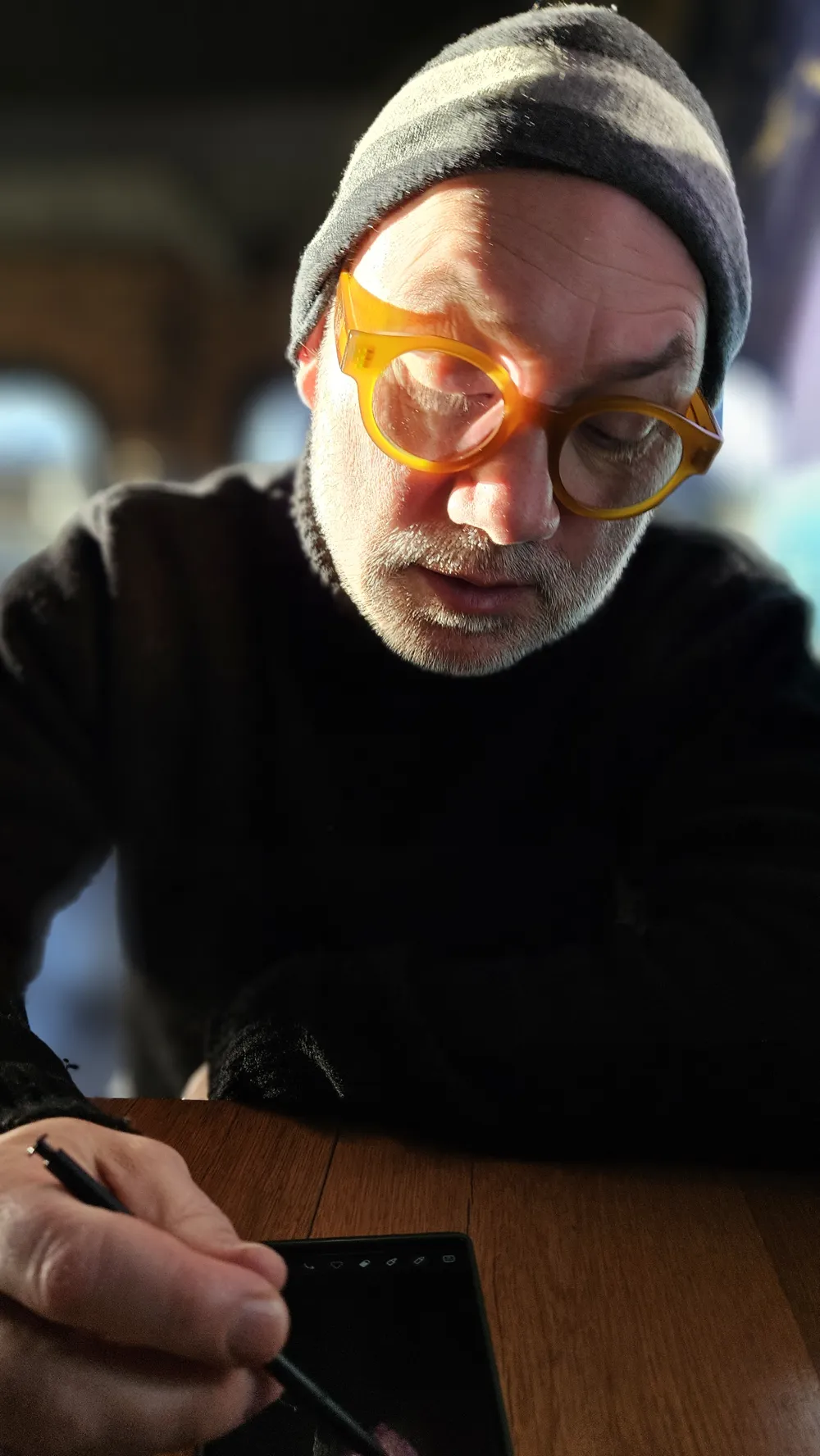 Me, wearing glasses, drawing on my phone.